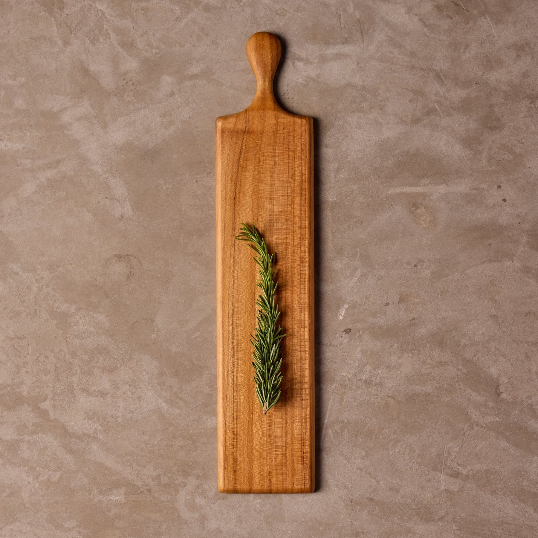 Slim teak serving paddle with a narrow presentation face and a wooden handle